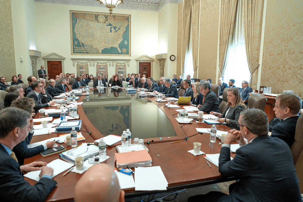 image MindViewMagazinecom Federal Open Market Committee meeting room showing officials in a formal discussion setting with a large map of the United States on the wall