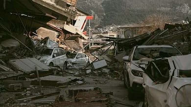 Severe earthquake damage in Antakya, Türkiye, with collapsed buildings and cars.