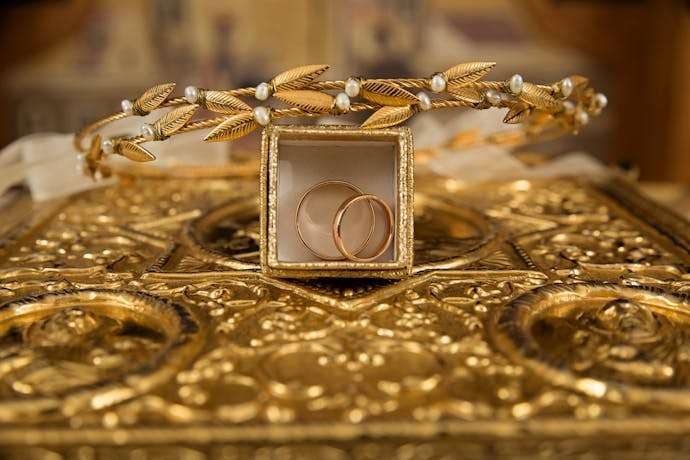 Photo by Pixabay MindViewMagazinecom Close up of gold wedding rings and a delicate tiara on an ornate golden background symbolizing luxury and elegance